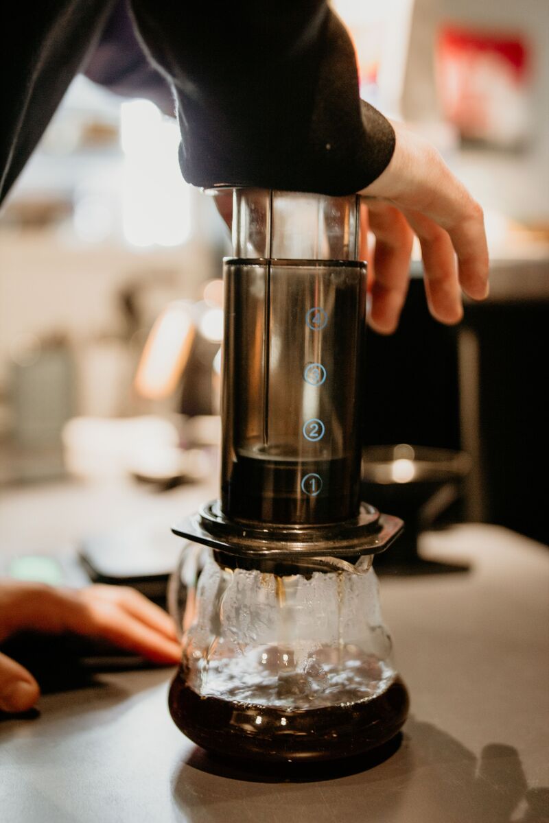 An AeroPress being pressed into a glass