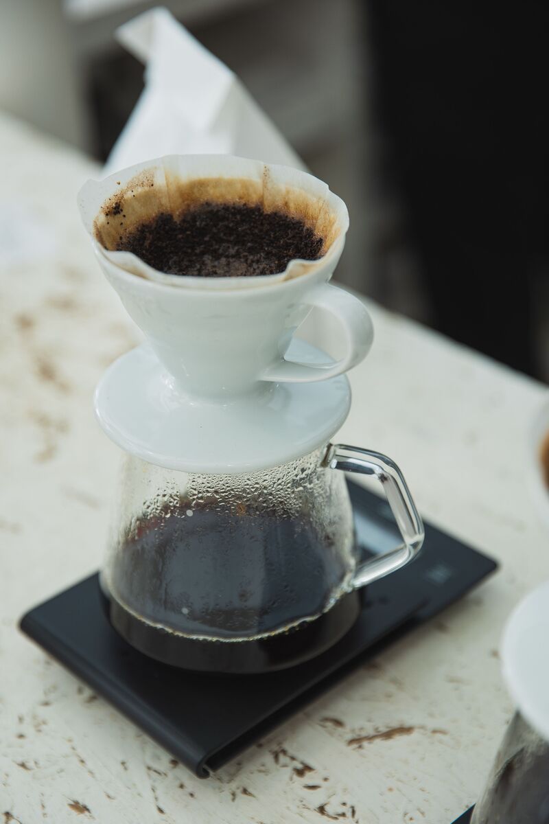 Pour-over coffee dripping through a V60 into a carafe on a scale